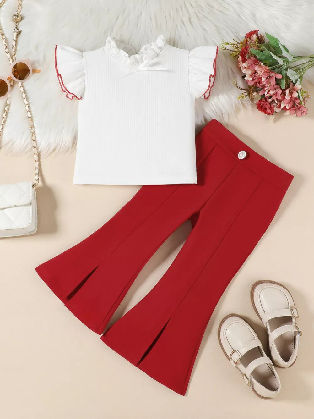 White ruffle-trimmed top with red trim and red flare pants with split hem
