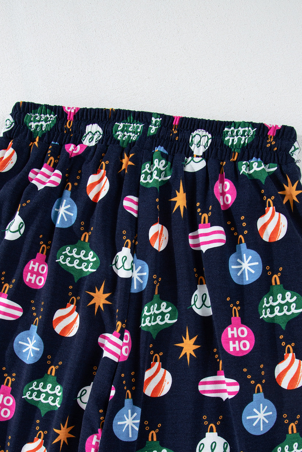 Navy blue lounge pants with festive bauble print and elastic waistband.