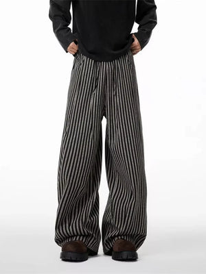 Striped wide-leg sweatpants in black and gray with drawstring waist.