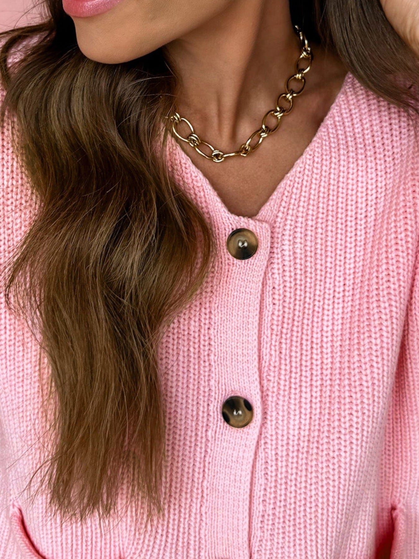 Pink acrylic button front V neck sweater vest with brown buttons.