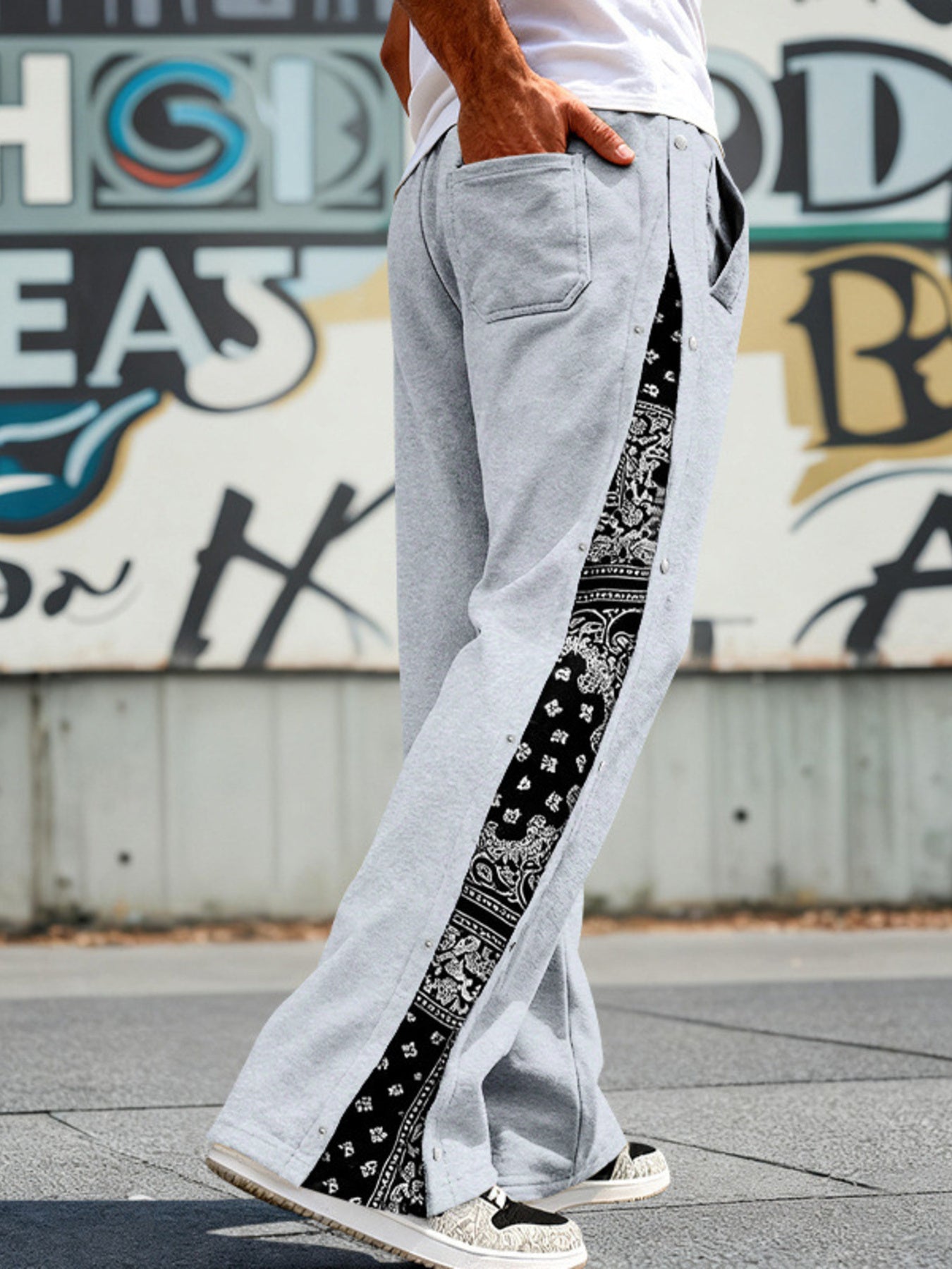 Light gray sweatpants with wide legs and a black bandana print side stripe with snaps.