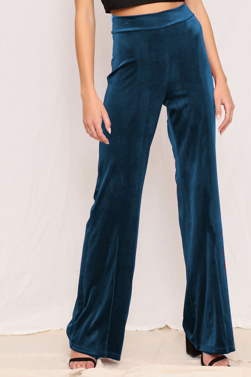 Plush velvet wide-leg trousers in deep teal with subtle red stripe detail on the side.