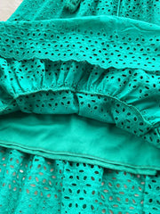 Green eyelet tiered maxi skirt with cutout details and a tassel drawstring.