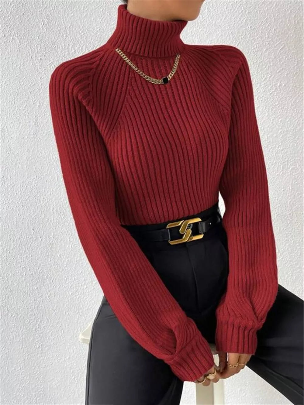 Burgundy ribbed turtleneck sweater with long sleeves and a gold chain necklace.