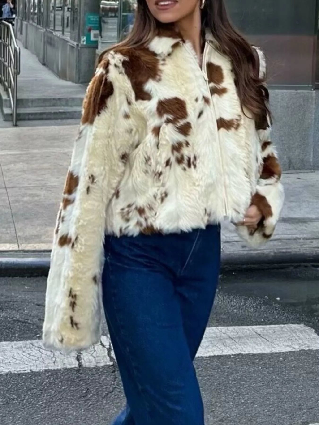 Cropped faux fur zip up jacket with brown and white cow print pattern.