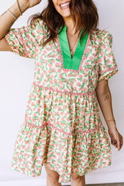 Women's tiered mini dress with pink floral print, green V-neck, and short sleeves.