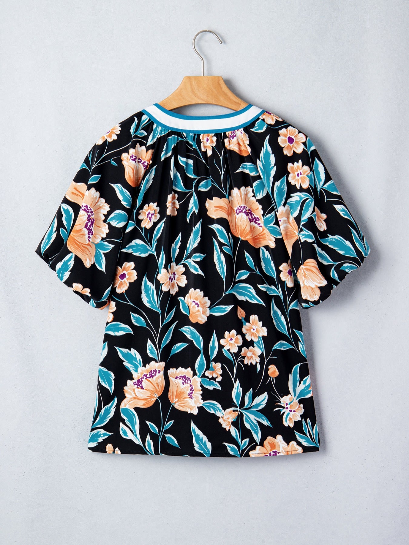 Black floral print blouse with bubble sleeves and a contrast neckline.