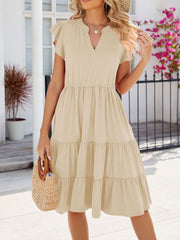 Tan ruffled midi dress with notched V-neck and tiered skirt.