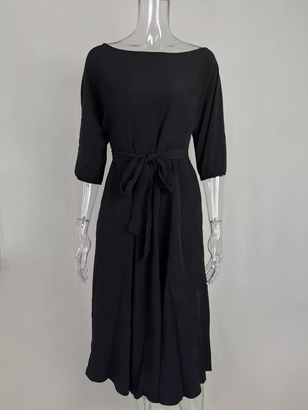 Black off-the-shoulder belted midi dress with 3/4 sleeves and a tie waist.