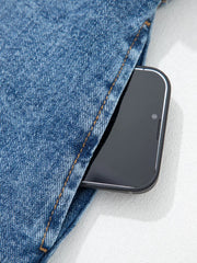 Belted denim dress pocket detail with a smartphone.