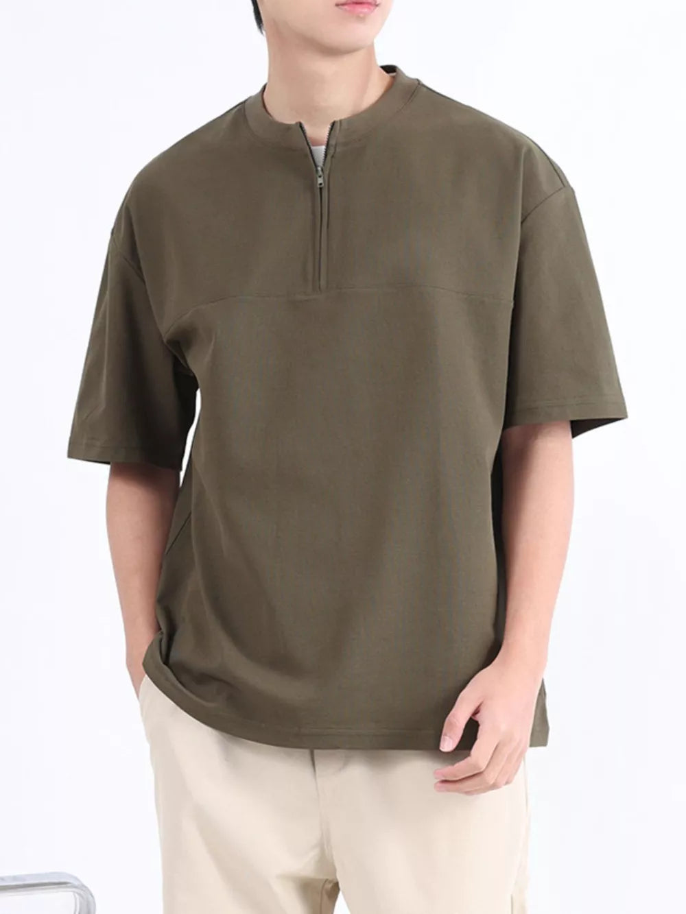 Men's dark green cotton half-zip t-shirt with short sleeves and a relaxed fit.