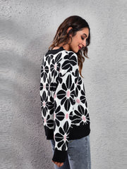 Black floral jacquard knit sweater with pink accents, crew neck, long sleeves.