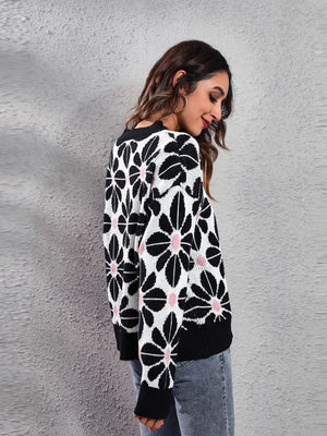Black floral jacquard knit sweater with pink accents, crew neck, long sleeves.