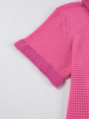 Pink waffle-knit maternity shirt with short sleeves and a textured cuff detail.