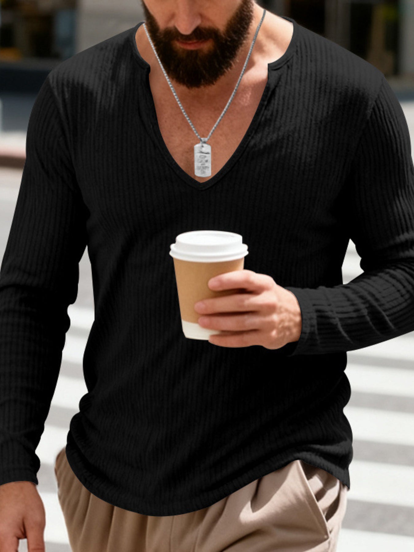 Black ribbed long sleeve t-shirt with deep V-neck, worn by a man holding a coffee cup.