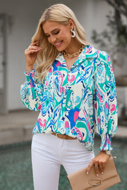 Women's abstract print blouse in blue and hot pink with gathered cuffs and a collared neckline.