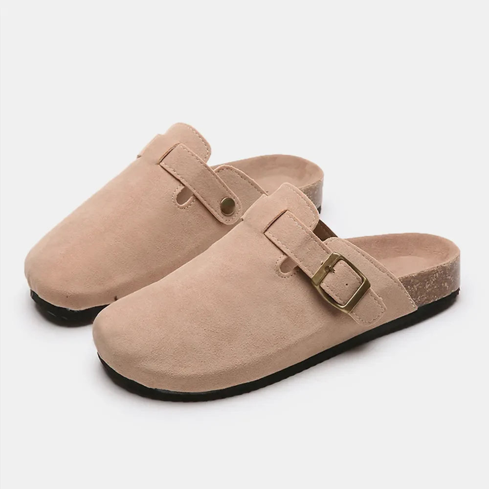 Beige suede clog slides with adjustable buckle and cork sole.