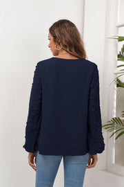 Dark Navy blouse with pom-pom detail on balloon sleeves and V-neckline.