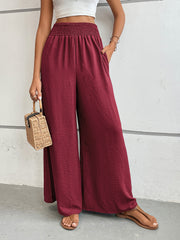 Burgundy textured palazzo lounge trousers with smocked waist and wide legs.