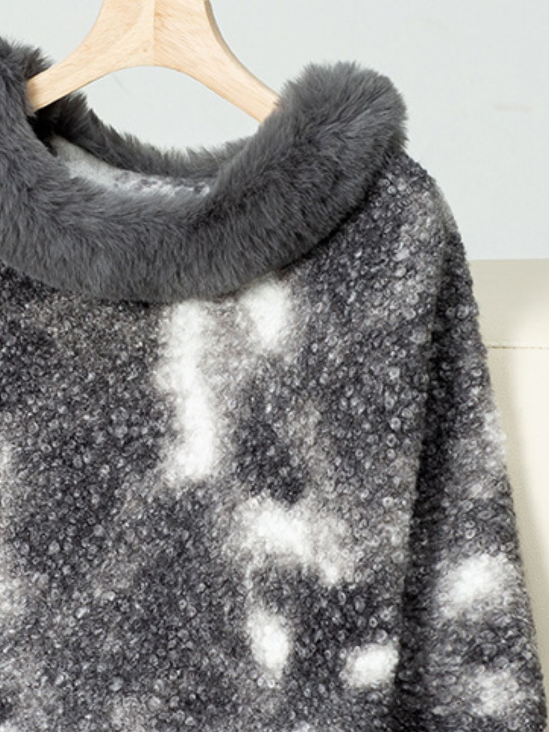 Faux fur trimmed camo poncho in dark gray with a textured knit and tie-dye pattern.