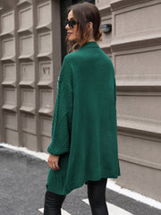 Green cable knit cardigan with pearl embellishments on the sleeves and a relaxed fit.