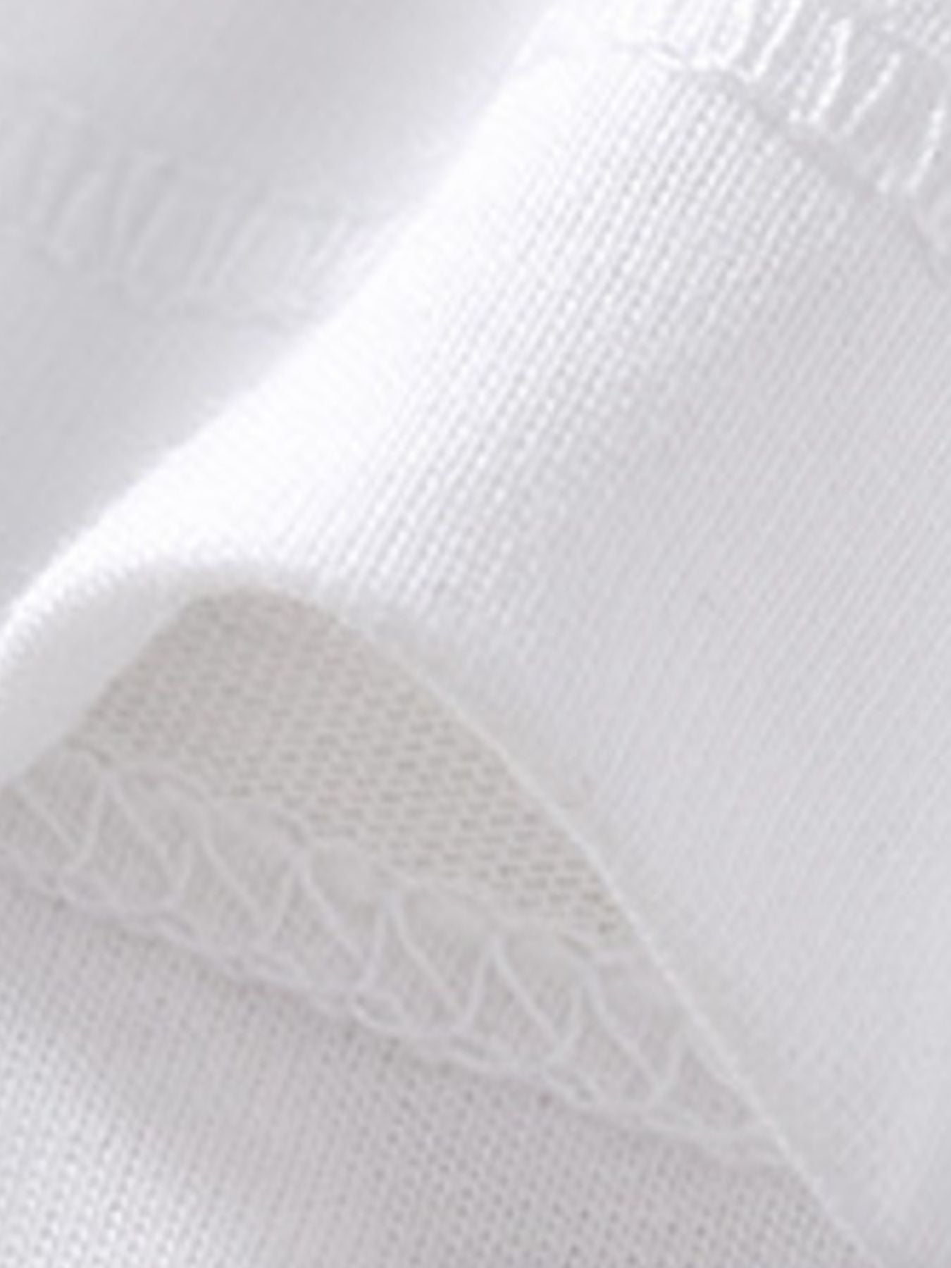White cotton polo shirt detail showing fabric texture and stitching.
