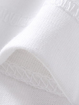 White cotton polo shirt detail showing fabric texture and stitching.