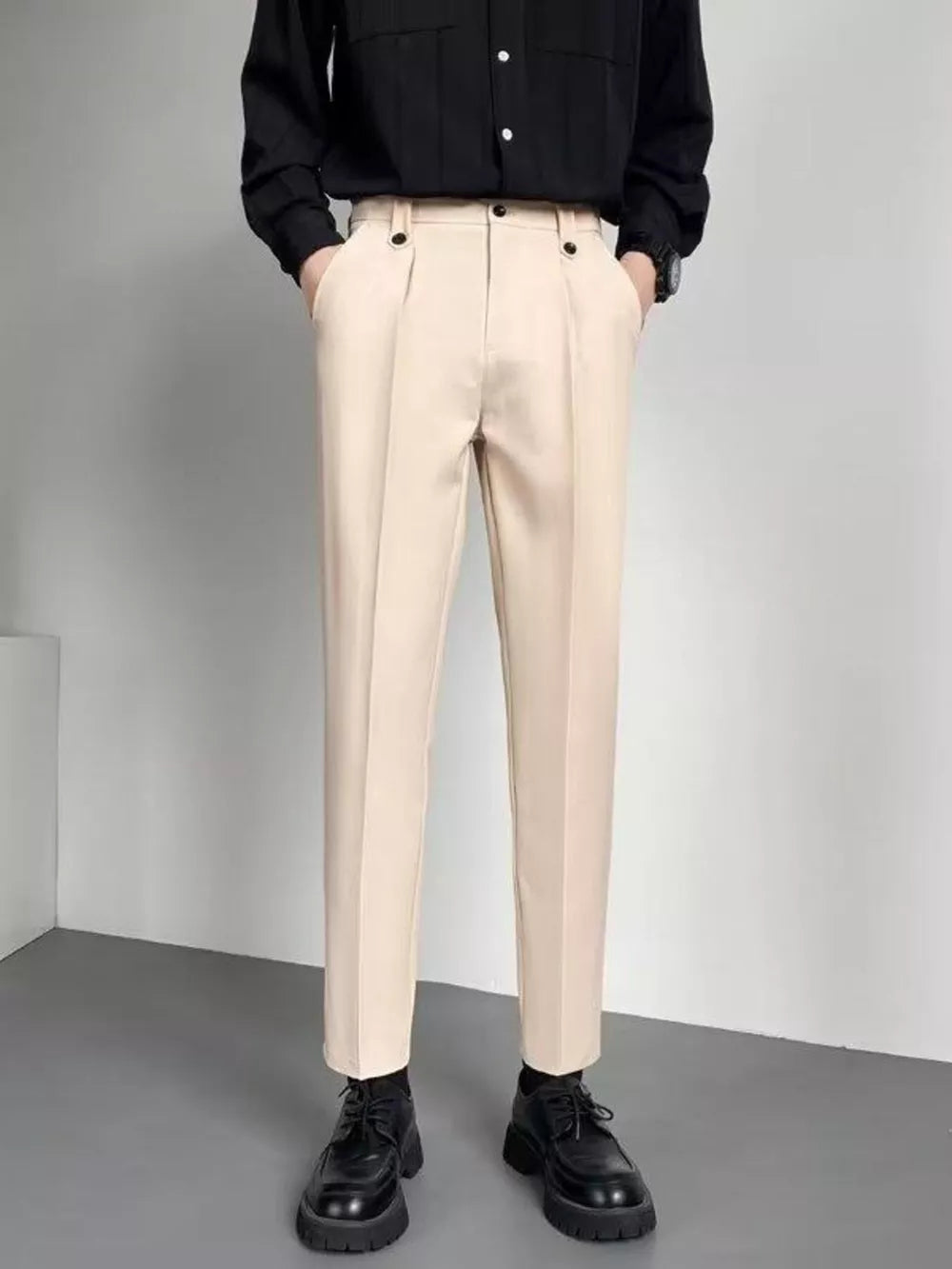 Men's beige slim fit ankle-length trousers with double button detail and front pleats.