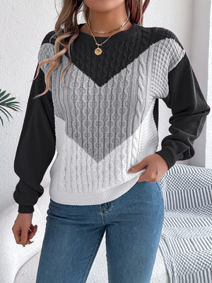 Chevron cable knit sweater with contrast black, gray, and white colorblock pattern.