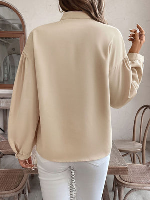 Tan blouse with balloon sleeves and a geometric yoke detail.