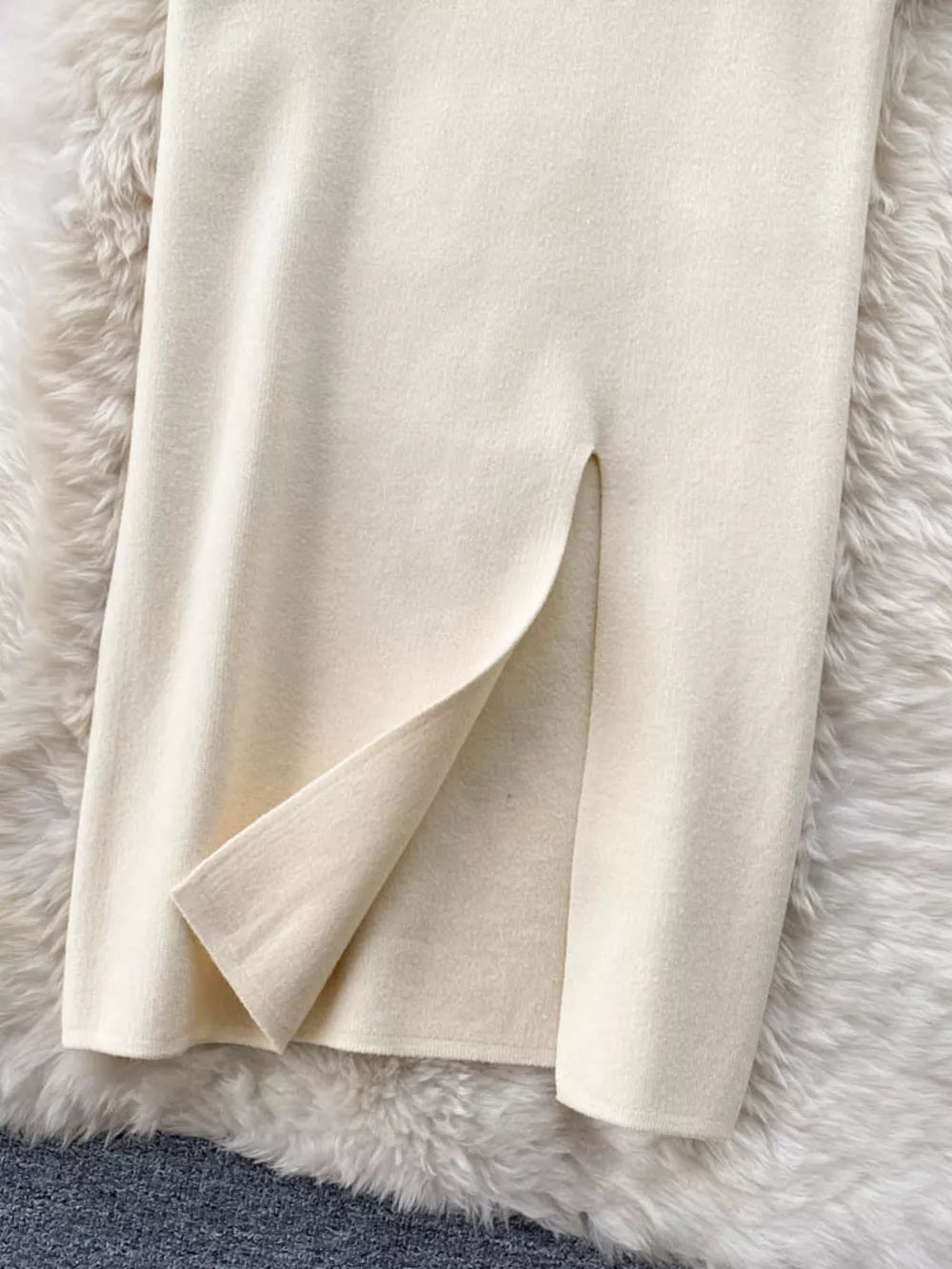 Chic off-white knit midi skirt with a side split detail.