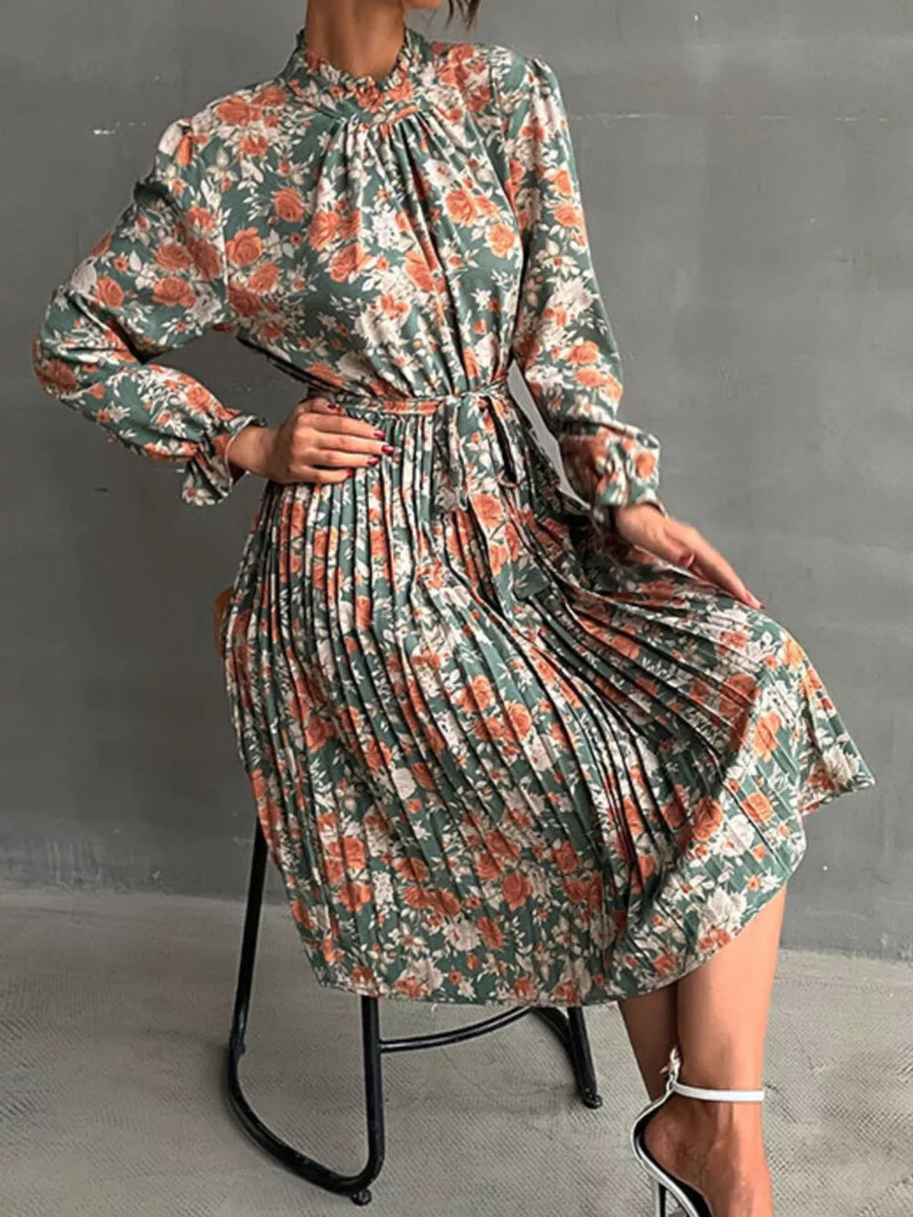 Green floral midi dress with pleated skirt, ruffled mock neck, and long sleeves.