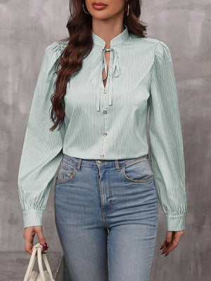 Green striped blouse with puff sleeves and neck tie detail.