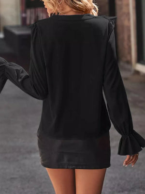 Black blouse with cascading ruffle sleeves and button front detail.