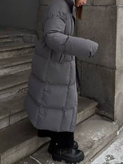 Dark gray padded puffer trench coat with tie-belt, long sleeves, and a stand-up collar.