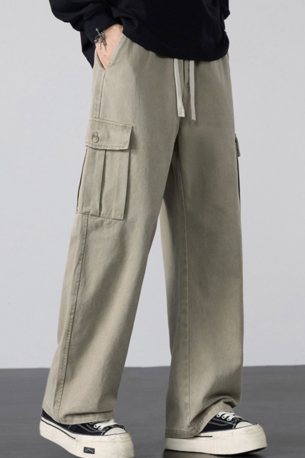 Khaki relaxed fit cargo sweatpants with drawstring and pleated cargo pockets.