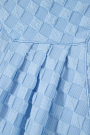 Light blue textured checkered button-strap palazzo jumpsuit detail