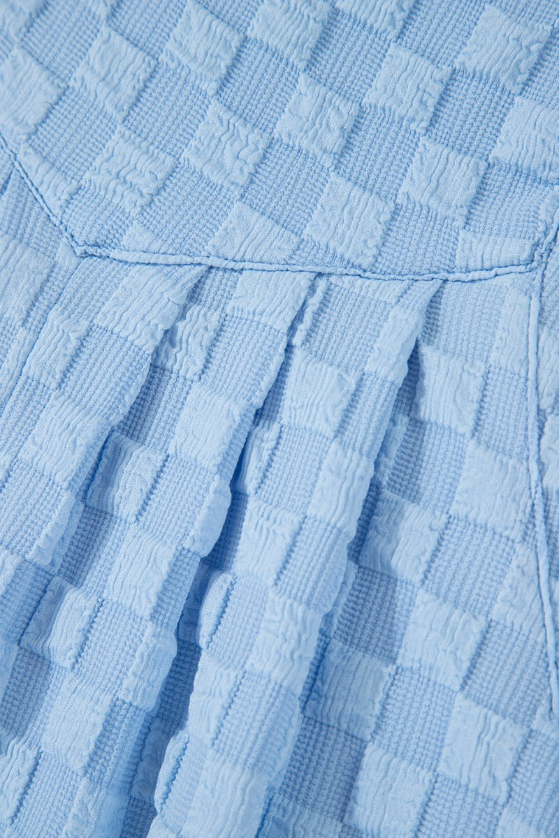 Light blue textured checkered button-strap palazzo jumpsuit detail