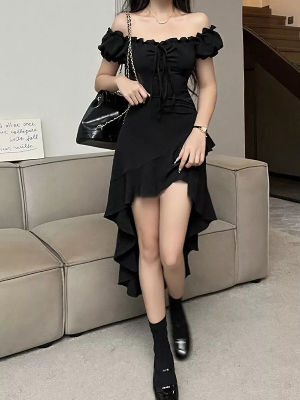 Black off-shoulder dress with ruffled asymmetrical hem and tie front detail