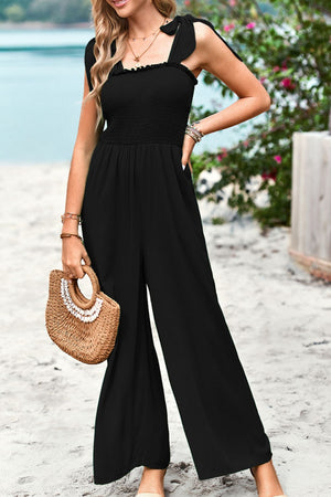 Black smocked bodice tie-strap palazzo jumpsuit with wide legs.