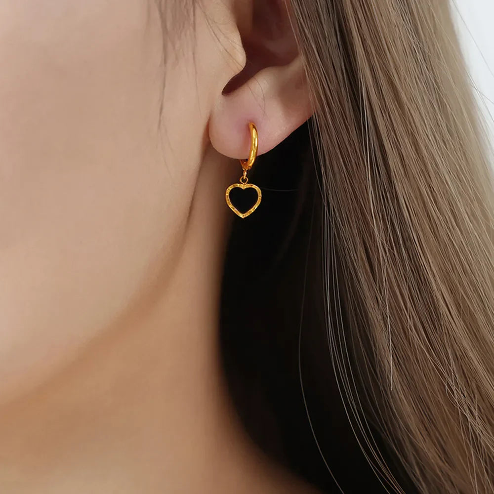 Gold hoop earrings with black enamel heart charms
