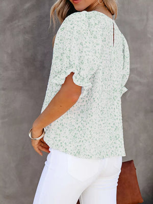 Maternity blouse in green floral print polyester with ruffle sleeves and smocked bodice.