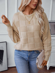 Tan checkerboard knit pullover sweater with crew neck and long sleeves.
