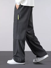 Men's gray loose fit cargo pants with zippered pocket detail and drawstring waist.