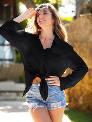 Black oversized linen beach shirt with tie front and buttoned closure, styled with denim shorts.