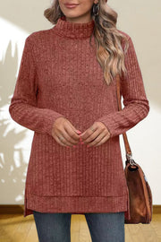 Ribbed knit turtleneck tunic top in Red Orange with side slits.