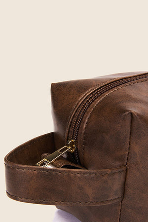 Textured faux leather travel case in caramel with a gold zipper and carry handle.