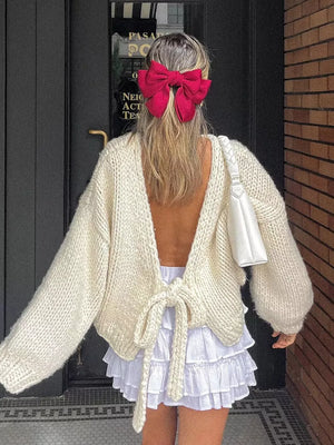 Cream textured tie-front knit cardigan with chunky sleeves and open back detail.