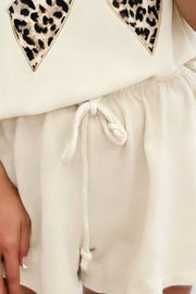Cream cotton outfit set with leopard print bowknot graphic and drawstring shorts.