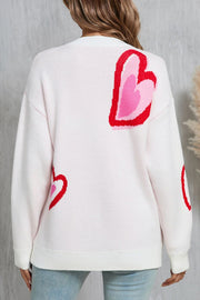 White acrylic sweater with intarsia heart motif pattern and crew neck.